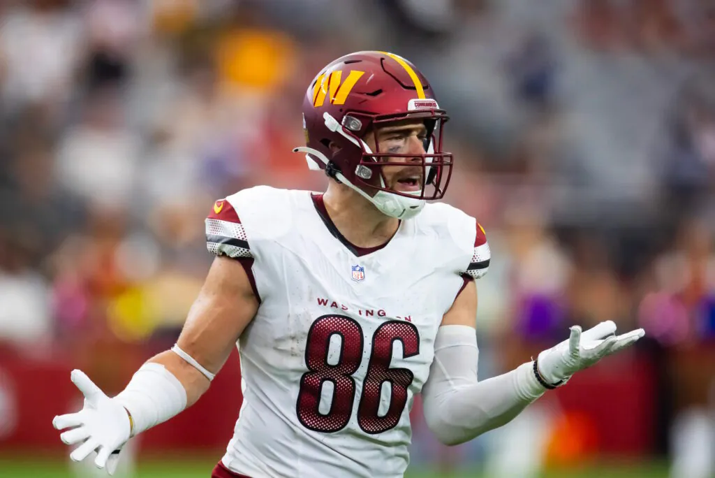a man in a helmet and in the uniform of an American football player is indignant on the field
